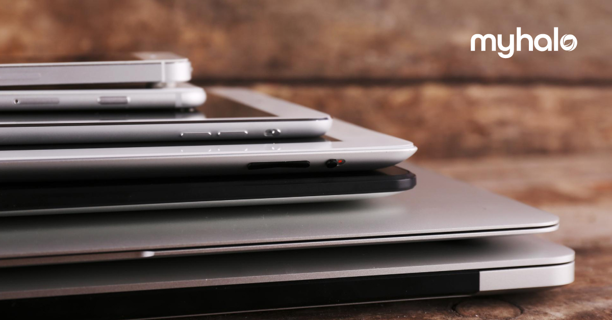 multiple laptops cluttered over one another